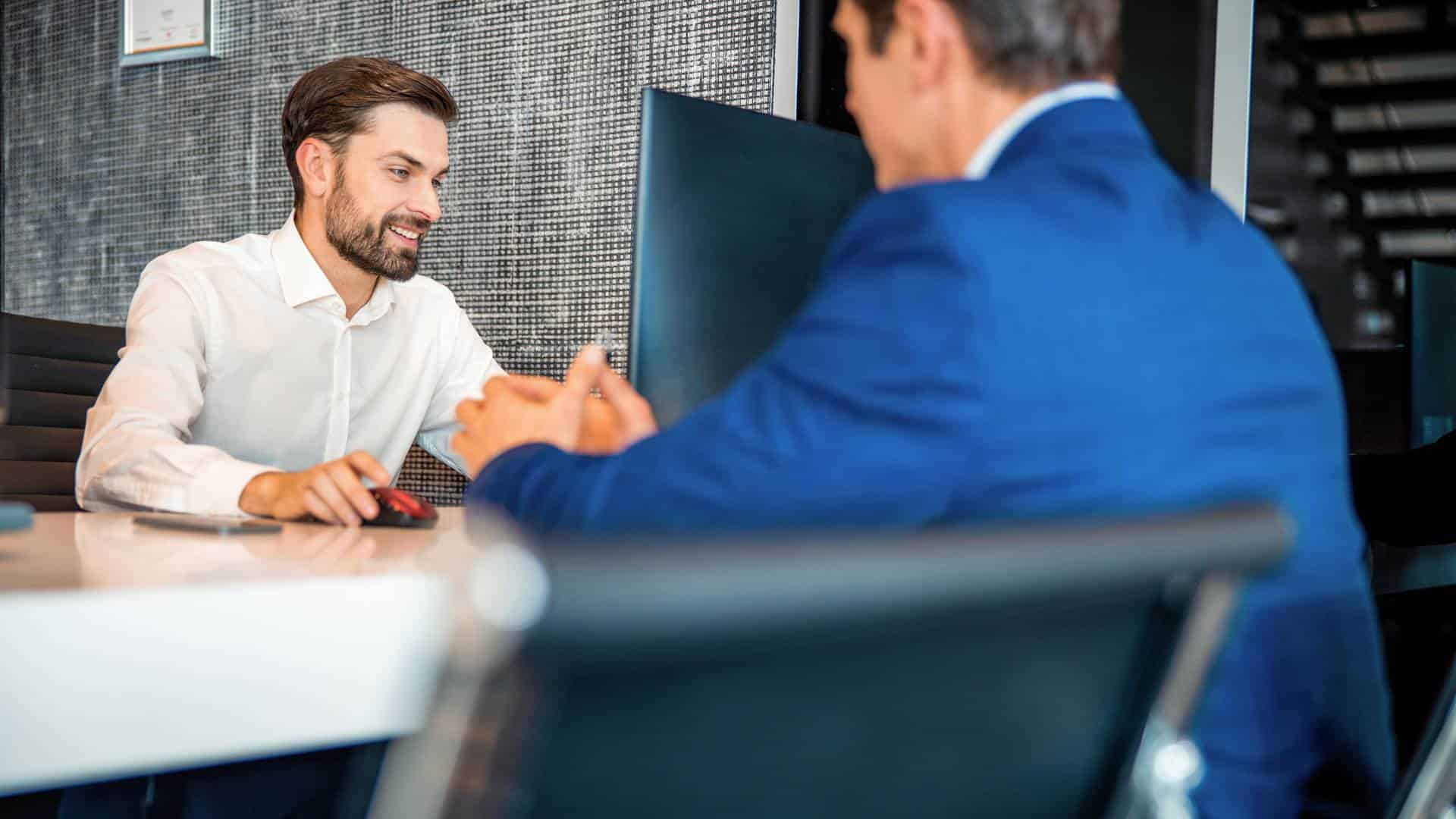 Un courtier aidant un client à remplir une demande d'ouverture de crédit